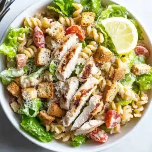 Recipe card for low-calorie chicken Caesar pasta salad with ingredients, instructions, and nutrition details.